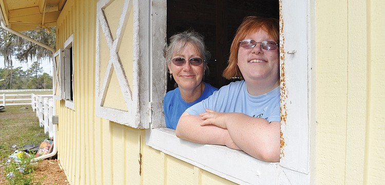 SMART Volunteer Executive Director Gail Clifton and SMART rider Jessica Stort were eager to show off one of the new barns. SMART moved to its new 23-acre home March 1. Published March 1, 2012.