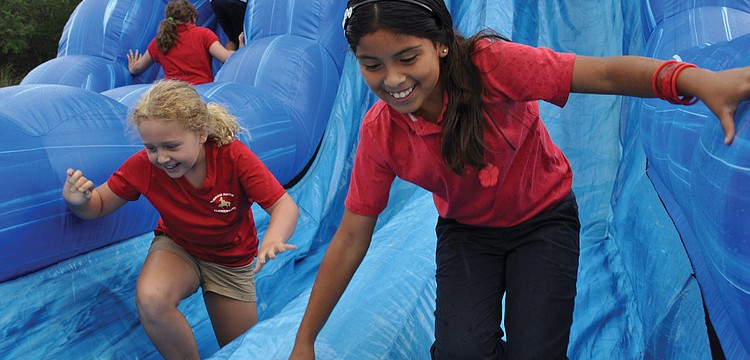 Braden River Elementaryâ€™s Lusero Acosta, front, and Lizzy Ebury, went on the slide as many times as they could, during the school's "Movin' and Groovin" Inflatables Day June 5. Published June 14, 2012.