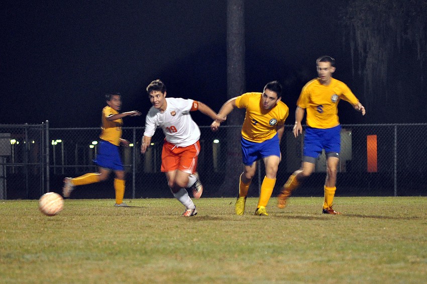 Sarasota High Schoolâ€™s Ian Grubb, No. 19, breaks away from a group of Sarasota Military Academy players Wednesday, Dec. 19, at Sarasota High School.