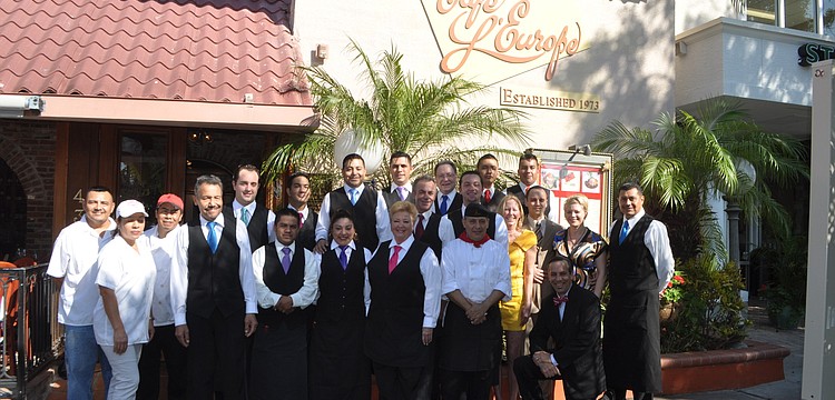 The staff of CafÃ© Lâ€™Europe gathers for a group picture before guests arrive to celebrate the restaurantâ€™s 40th anniversary.