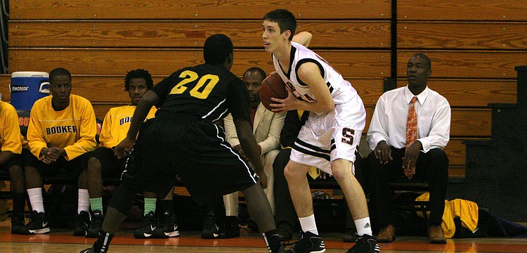Booker High Schoolâ€™s Terrance Bradley, No. 20, guards Sarasota High Schoolâ€™s Blake Haga, No. 12, during Monday nightâ€™s game at Sarasota High School.