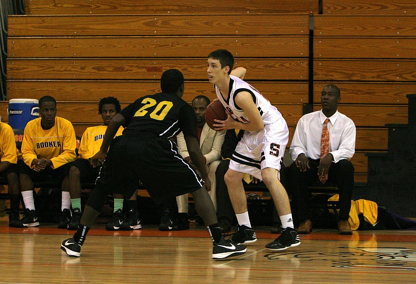 Booker High Schoolâ€™s Terrance Bradley, No. 20, guards Sarasota High Schoolâ€™s Blake Haga, No. 12, during Monday nightâ€™s game at Sarasota High School.
