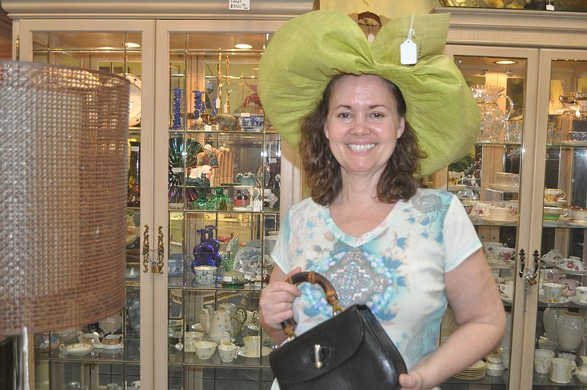 Stephanie Claussen, owner of Steffâ€™s Stuff Antiques, models a sun hat (â€œkeeps the wrinkles away,â€ she says) and a vintage pocketbook from Saks Fifth Avenue.