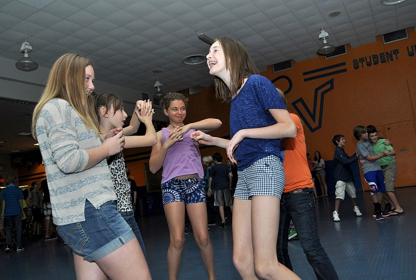 Abby Quigley and Caroline Middleton dance with friends.