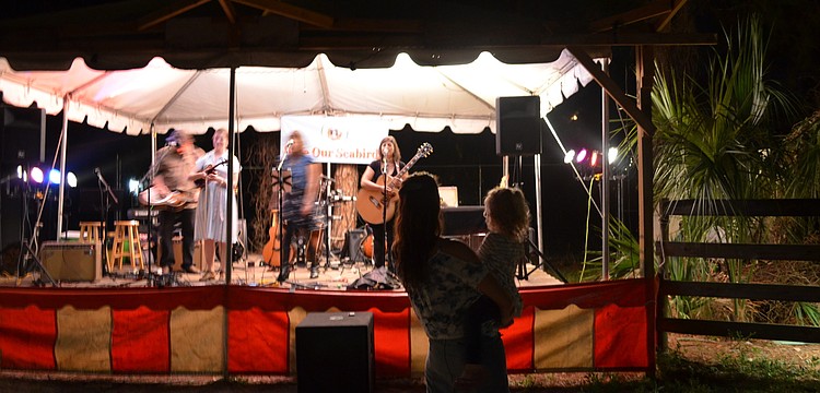 Passerine, which means songbird, performs as Lisamichelle Lemurian sways to the music with her daughter Trinity.