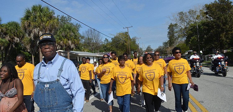 Community members march down Dr. Martin Luther King Way.