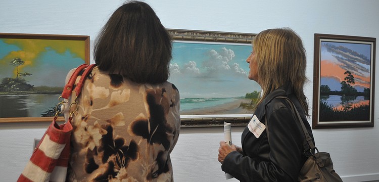 Terri Baker and Barbara Harrison discuss a seashore painting.