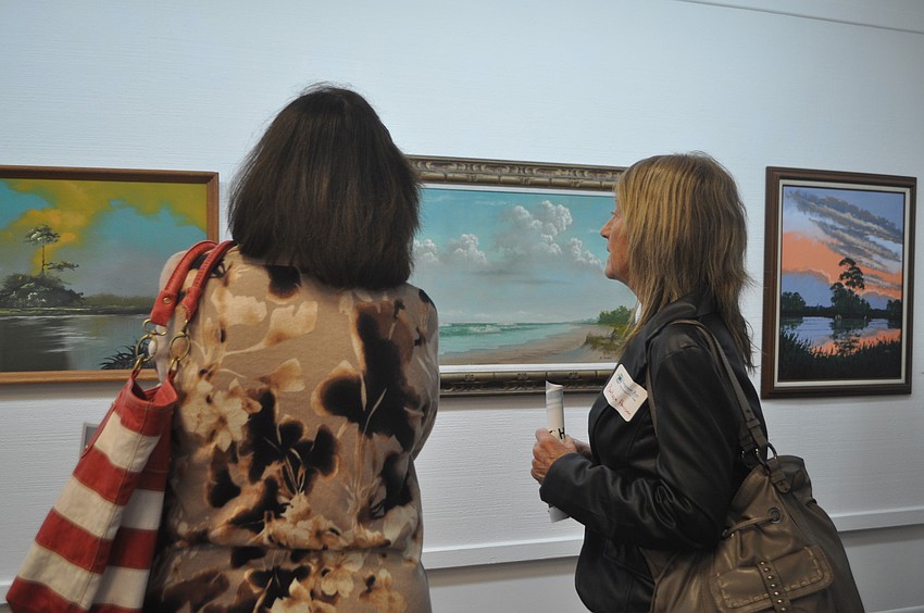Terri Baker and Barbara Harrison discuss a seashore painting.