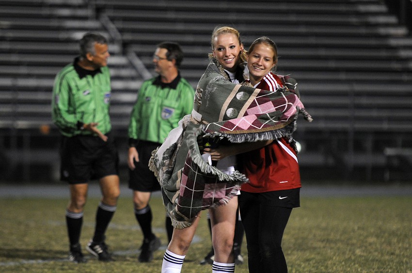 Aubrey Riggins celebrates with goalkeeper Alex Latham following the Lady Mustangs 4-1 regional quarterfinal victory over Cape Coral Ida Baker Jan. 23.