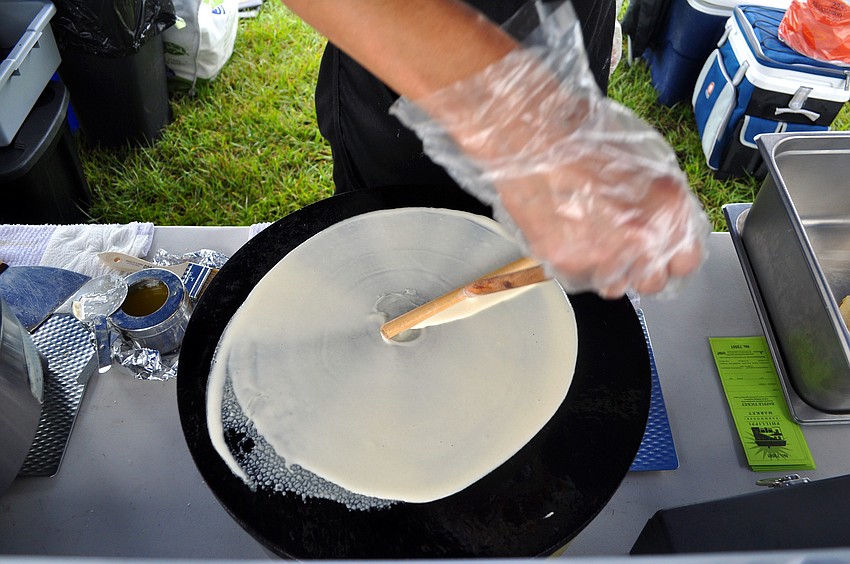 Roverta Winn makes a crepe at her stand, Rovertaâ€™s Crepeâ€™s, Wednesday, Oct. 3, the opening day of the Phillippi Farmhouse Market.