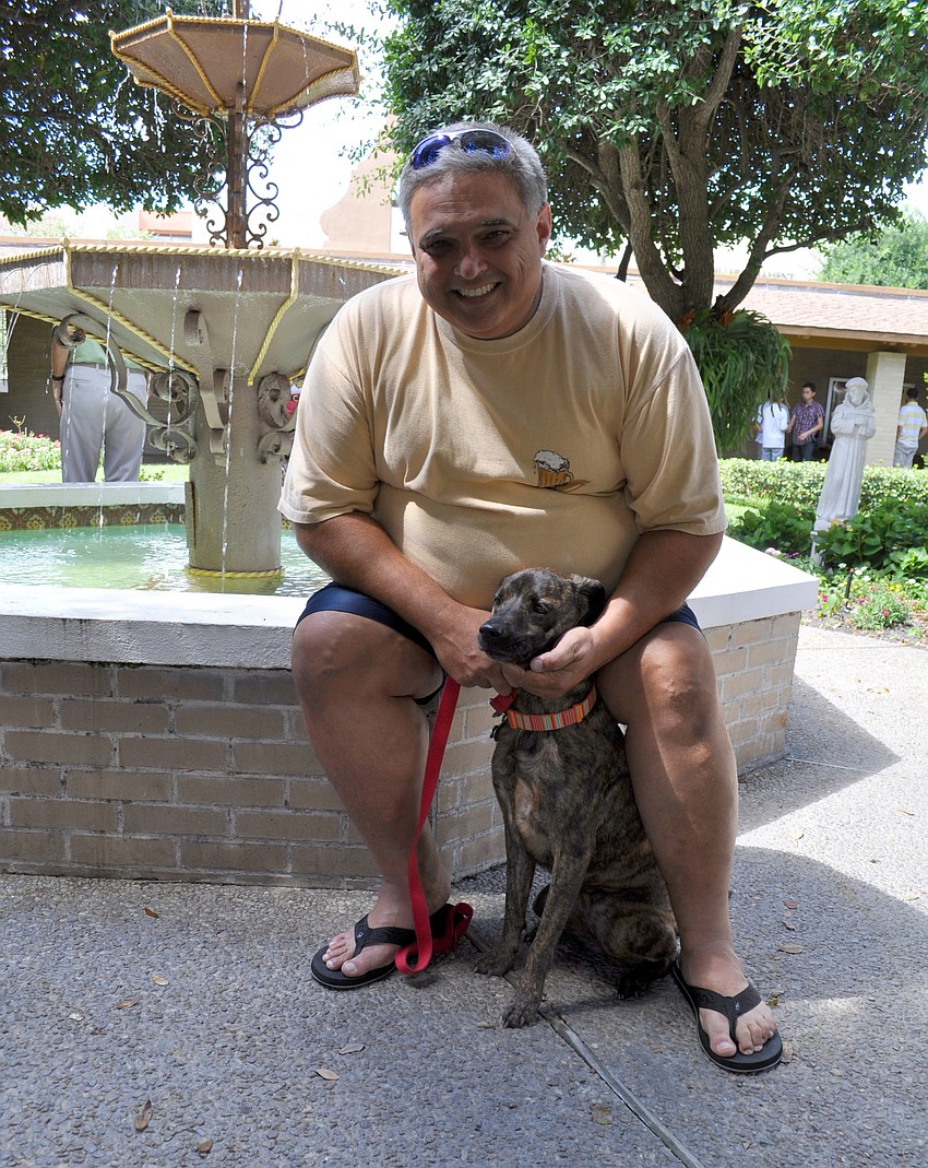 Andy Rzonca waits to have his dog, Shadow, blessed.