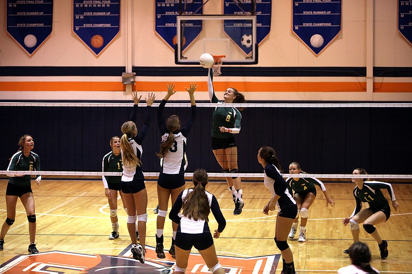 Tori Biach, No. 8, jumps up to spike the ball while Natalie Buffett, No. 4, and Gabriella Costa, No. 3, prepare to block Biachâ€™s shot.