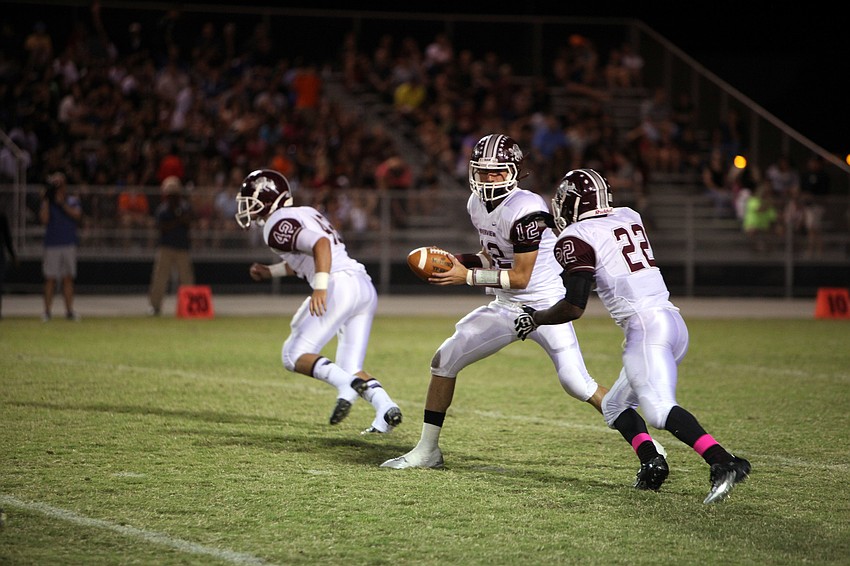 Dominic Marino, No. 12, prepares to pass the ball off to Karan Higdon, No. 22.
