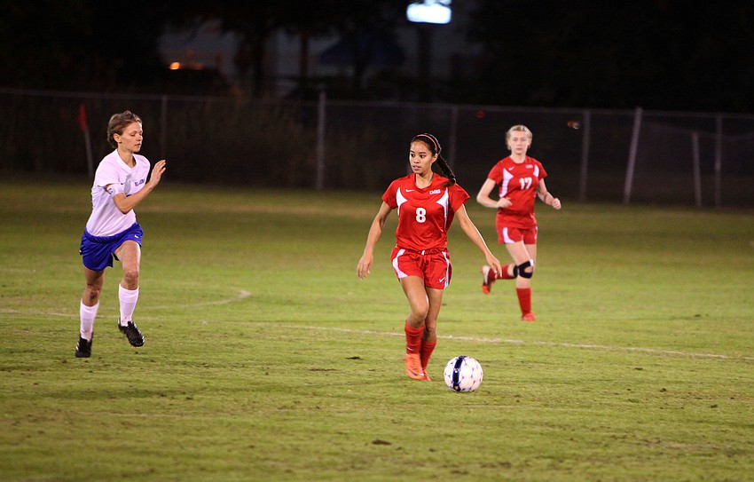 Cardinal Mooneyâ€™s Jasmine Rosales, No. 8, prepares to kick the ball up the field as Sarasota Christianâ€™s Danielle Buncik, No. 6, gains on Rosales Monday, Nov. 26, at Sarasota Christian.