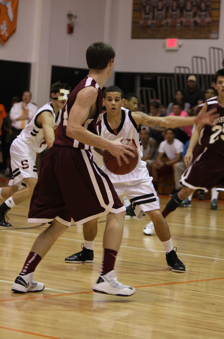 Sarasotaâ€™s Justin Robbins, No. 13, tries to block Riverviewâ€™s Vic Sinopoli, No. 14, from passing the ball.