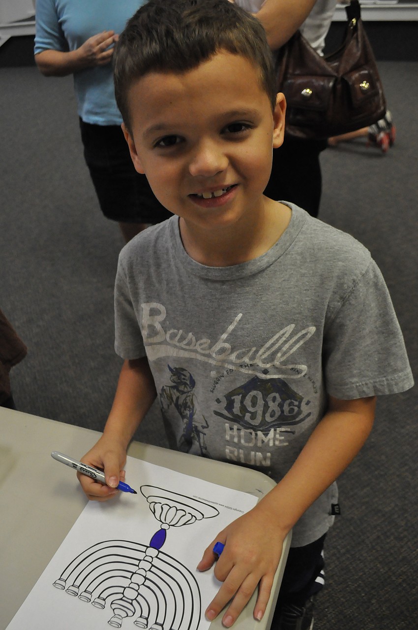 Logan Rosenberg colors a menorah.