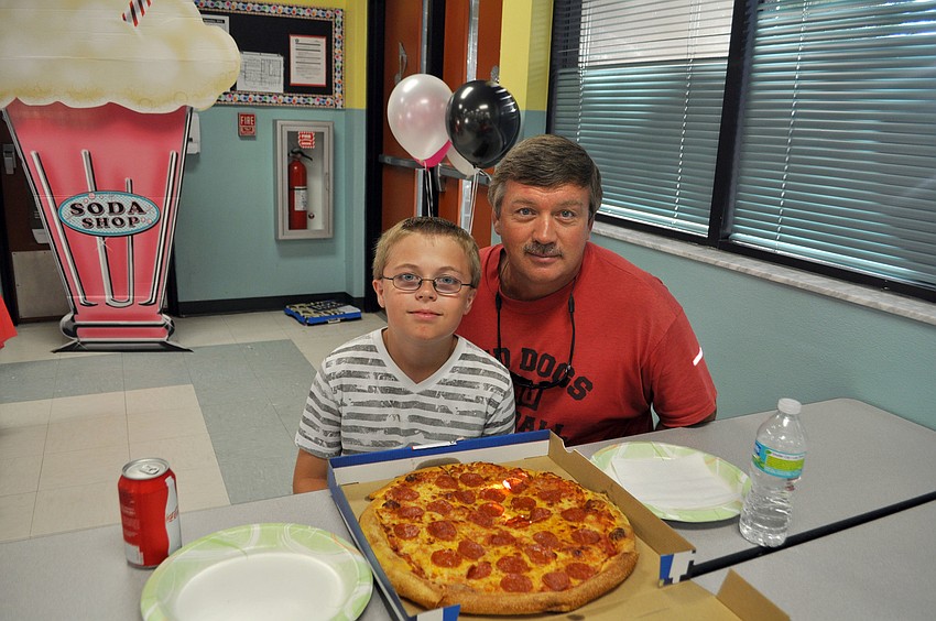Earl Nichols enjoys a pizza with his son Devin.