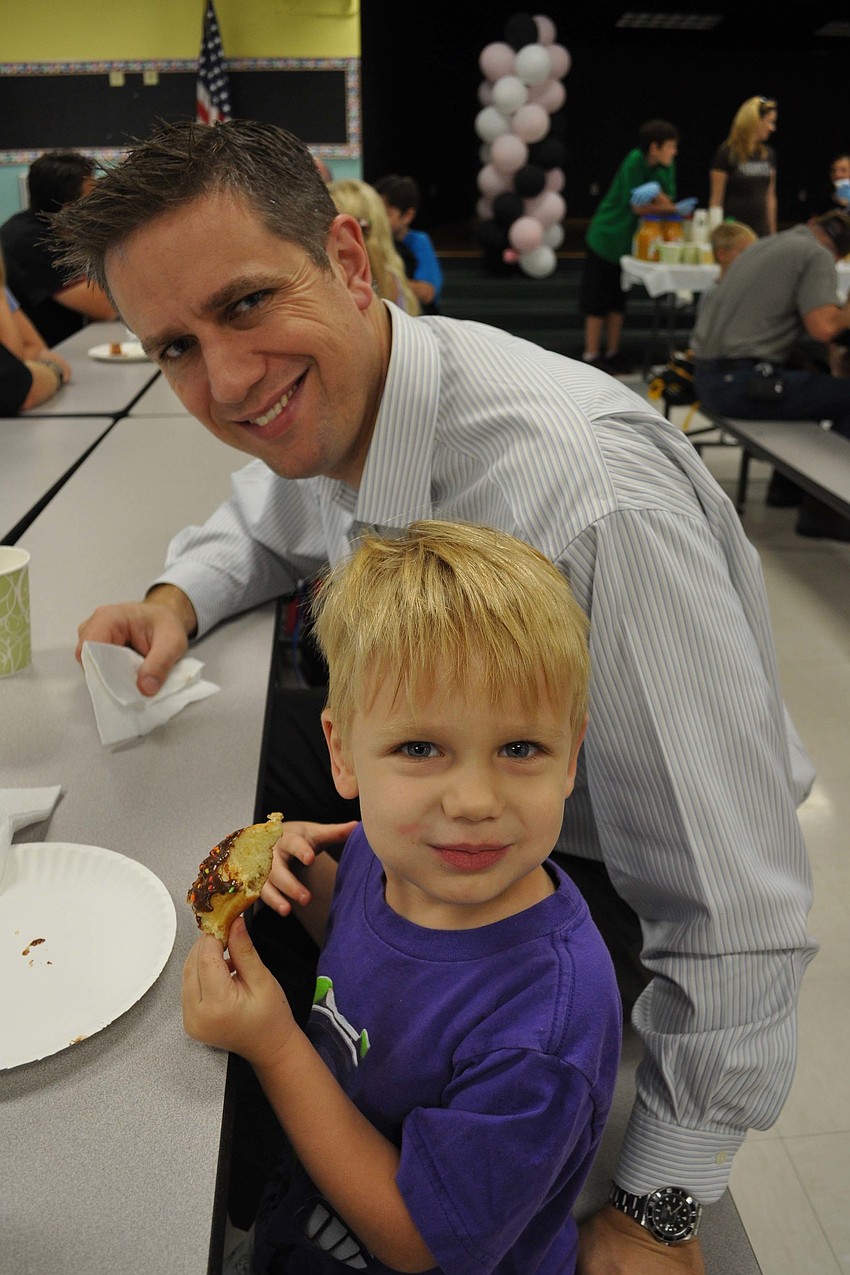 Caden Fluck was all smiles as he munched on doughnuts with his father, Rob.