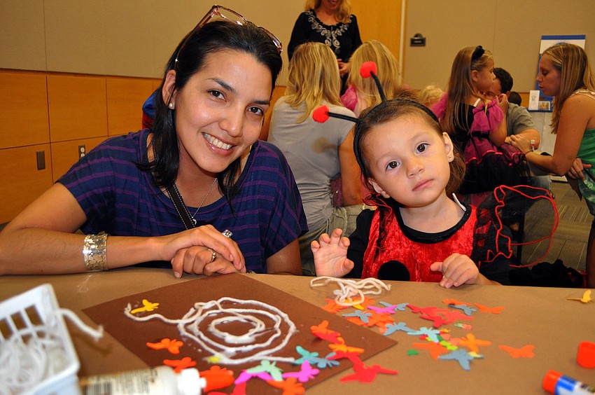 Claudia Oviedo and her daughter, Valentina, 20 mos., work on making a spider web Wednesday, Oct. 24, at Selby Public Libraryâ€™s Halloween Party.