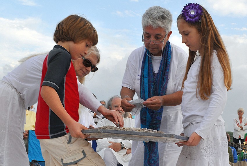 Judi Cannon placed the Mombasa sand, representing her sister, as Mooy placed sands from Tibet and the Hop and Toas Native American communities while Gabriel and Ella Mirman held the center of the mandala.