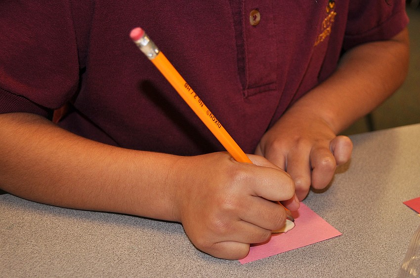 Leslie Vences-Avena traces Santaâ€™s nose for her Christmas card activity Friday, Dec. 14, at Tuttle Elementary.