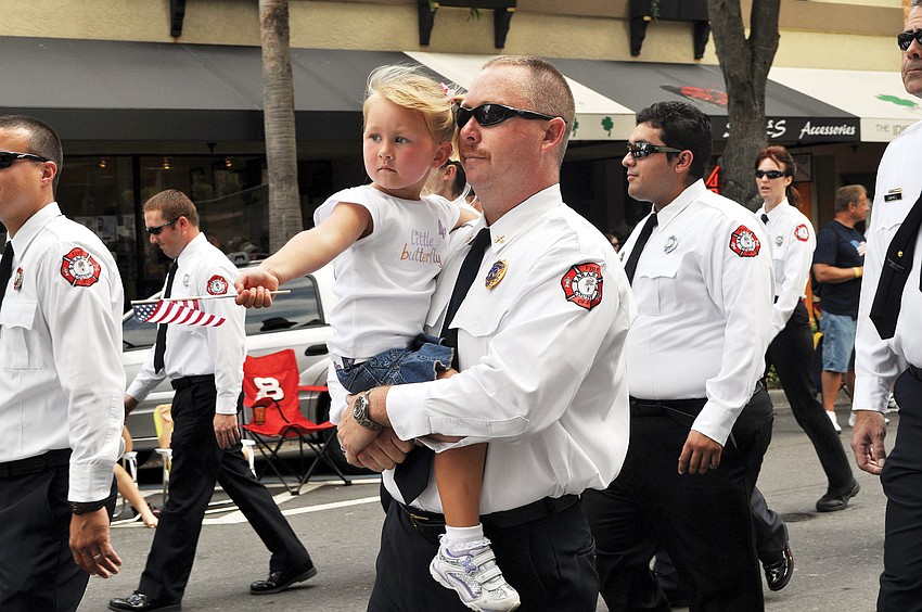 Glenn Snyder carries his daughter, Peyton, 3, in the annual downtown Sarasota Memorial Day Parade.