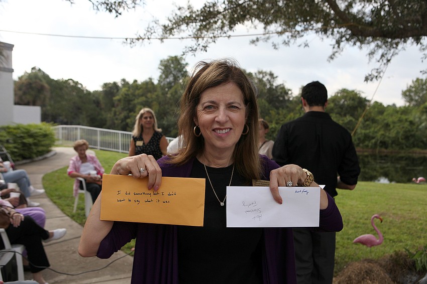 Judith Yaeger holds up two of the envelopes filled with slips of paper that involve different sins people may have committed over the last year.