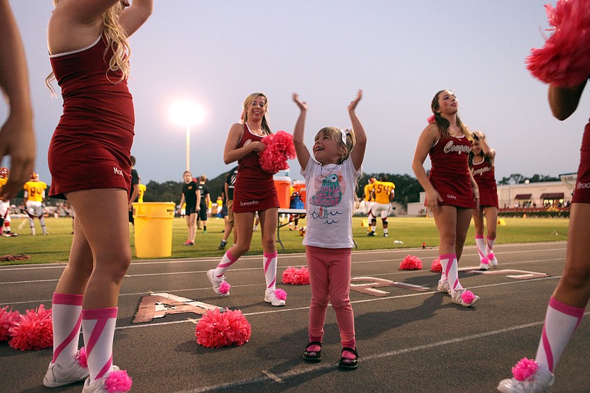 Kayla Kusko, 4, got the chance to cheer down on the sidelines with the Cardinal Mooney cheerleaders Friday, Oct. 12, during Cardinal Mooneyâ€™s homecoming game.