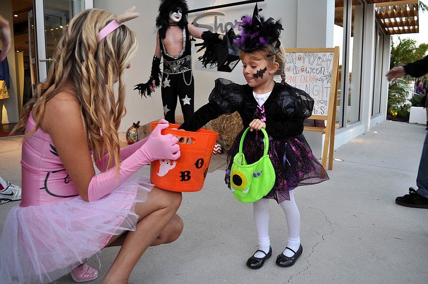 Frankie Bersch, 3, gets some candy from Stephanie Schenk Wednesday, Oct. 31, on St. Armands Circle.