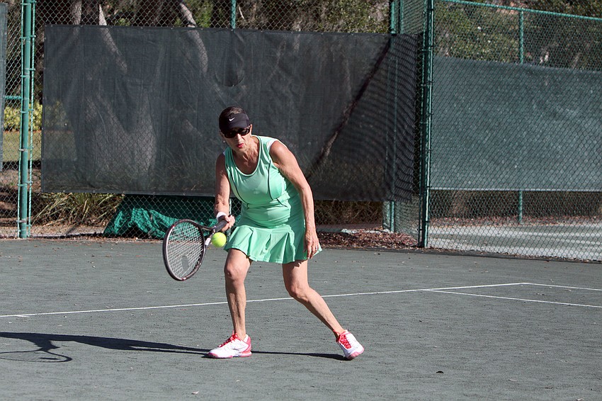 Pat Maxson goes for a forehand shot in her match Friday, Dec. 7, against Mary Lou Johnson in the Observer Challenge.