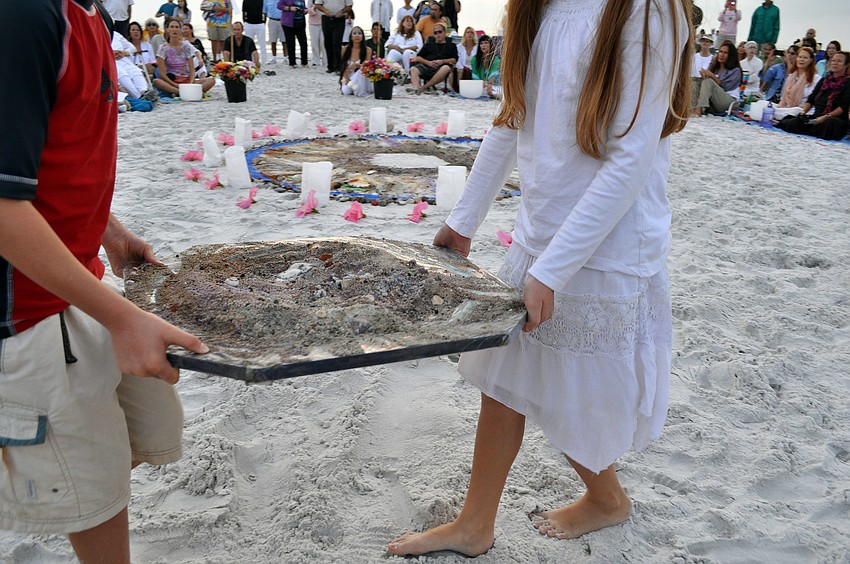Gabriel and Ella Mirman walked around the circle with a pile of the mixed sand Wednesday, Dec. 12, during the 12.12.12 Sands of the World Mandala on South Lido beach.