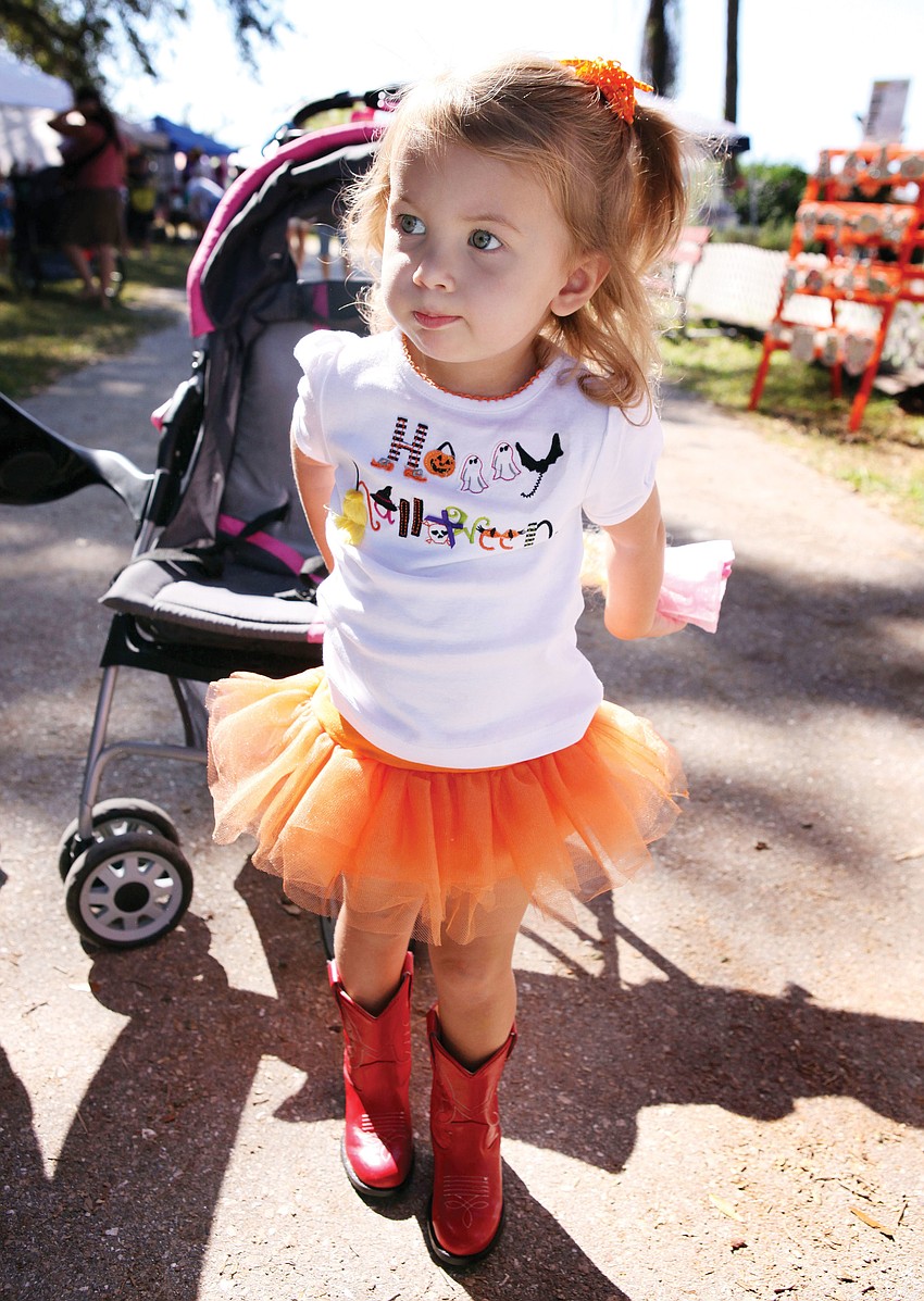 Samantha Chessler, 2, had fun wearing a â€œHappy Halloweenâ€ shirt, orange tutu and red cowgirl boots at the 24th annual Pumpkin Festival at Fruitville Grove.