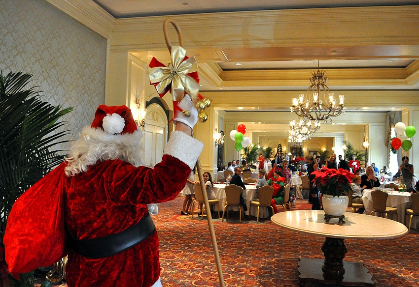 Santa makes his way to the breakfast to see the children anxiously waiting to sit on his lap.