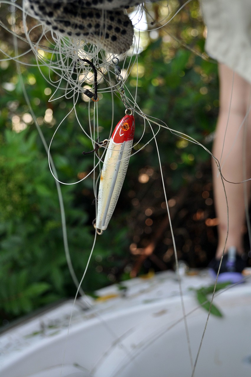 A fishing lure with a big mass of fishing line attached.