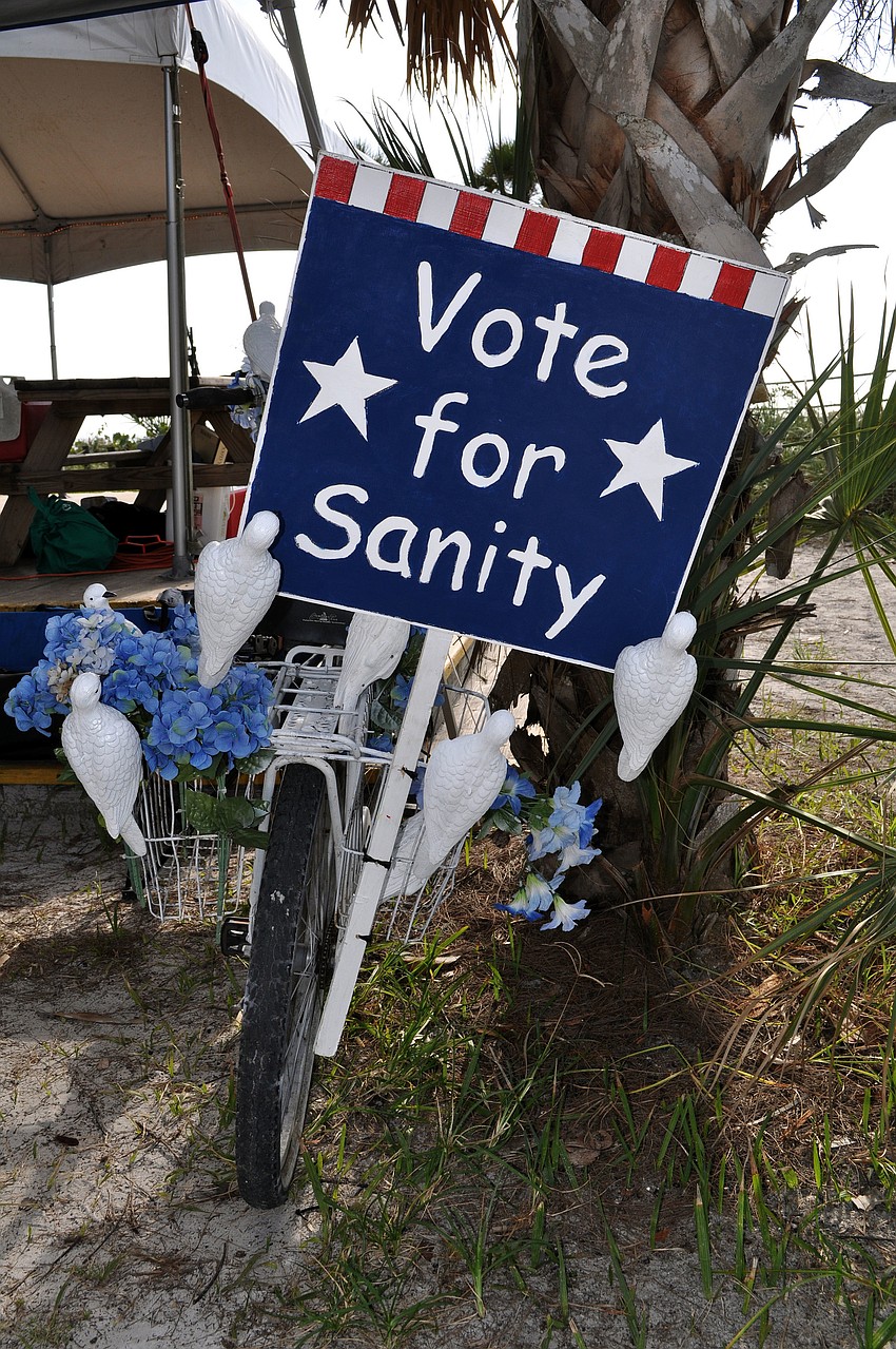 A bicycle decorated in fake blue flowers and white doves had a sign on the back saying, â€œVote for Sanityâ€.