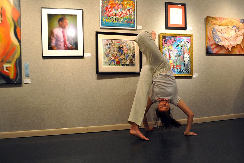 Molly Nichols goes upside-down as she makes her way around the Itâ€™s Political! exhibit Thursday, Oct. 18,  at Art Center Sarasota.