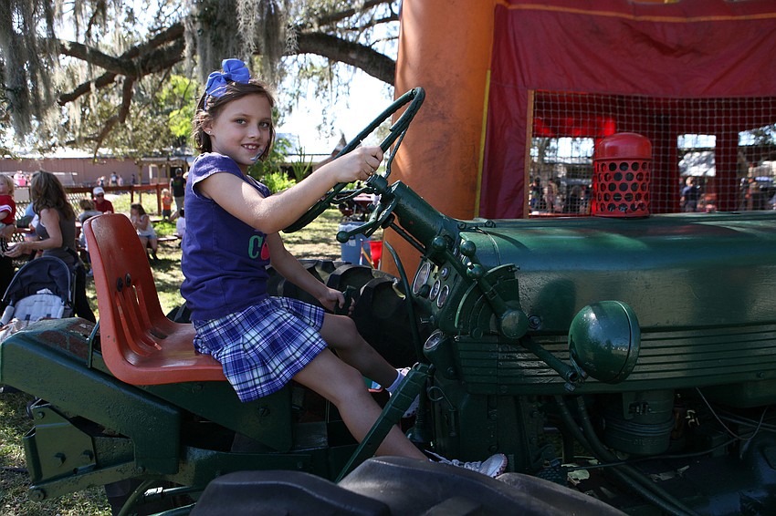 Lauren Van Nostrand, 7, pretends to drive a big tractor.