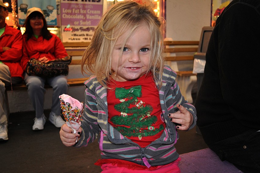 Lilly Robbins, 3 Â½, enjoys some strawberry ice cream outside of Big Olaf Saturday, Nov. 24, during Siesta Keyâ€™s Light Up the Village parade.