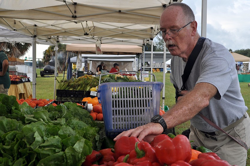 Kevin McDonnell shops for produce from Brownâ€™s Grove Wednesday, Oct. 3, the opening day of the Phillippi Farmhouse Market.