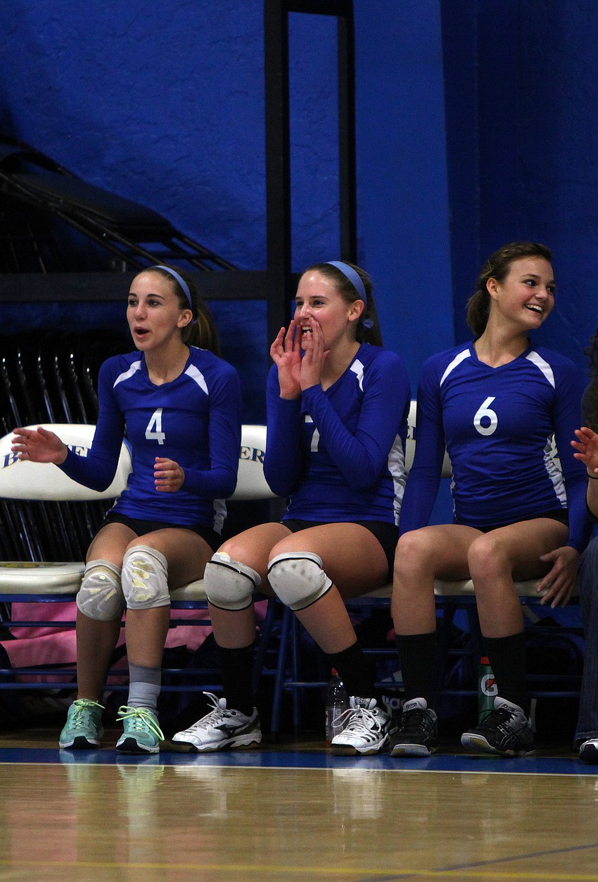 Paige Troyer, No. 4, Chyenne Miller, No. 7, and Andrea Wittmer, No. 6, cheer on their teammates from the sidelines.