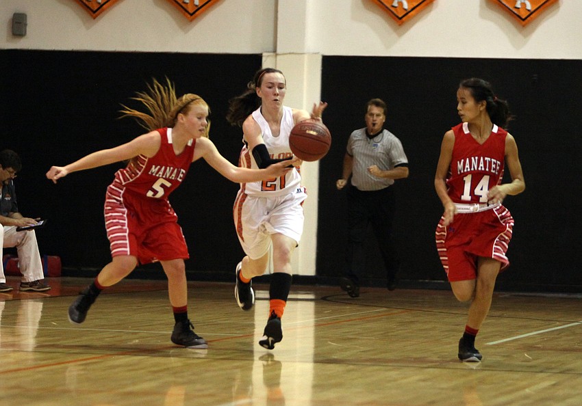 Manateeâ€™s Brittney Hartwig, No. 5, Sarasotaâ€™s Emily Harding, No. 21, and Manateeâ€™s Nicole Hittel, No. 14, all try to take possession of a loose ball.
