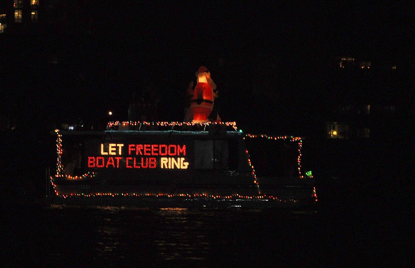 An inflatable Santa was placed on the top of this boat that read â€œLet Freedom Boat Club Ringâ€.