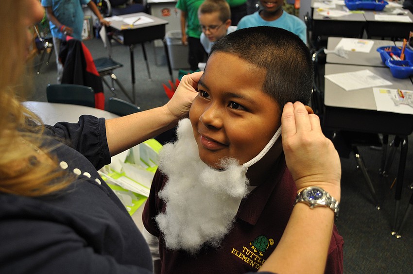 Ms. Tara Greenbaum helps turn Darian Toledo into Santa Claus for their performance of â€œOlive, the other reindeerâ€.