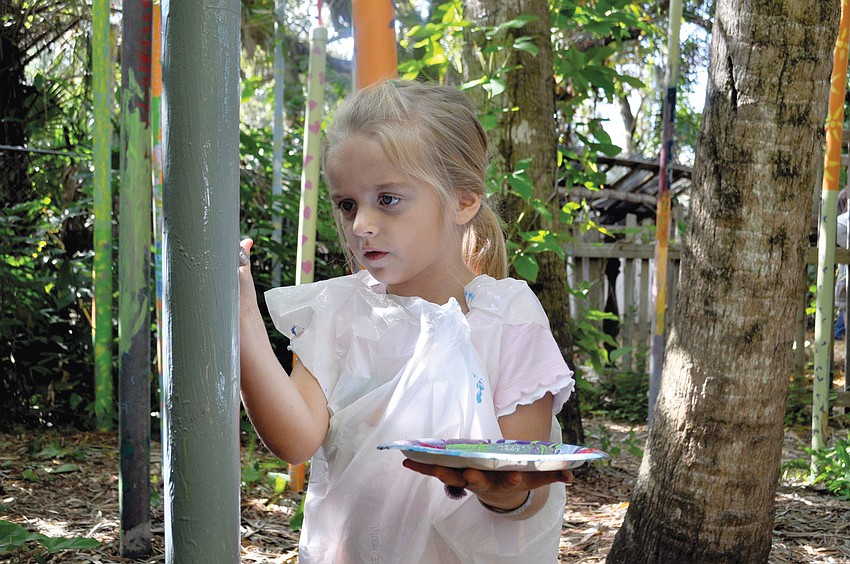 Liana Schlaybach paints in the garden at the sixth annual Children's Reading and Art at the Sarasota Children's Garden.