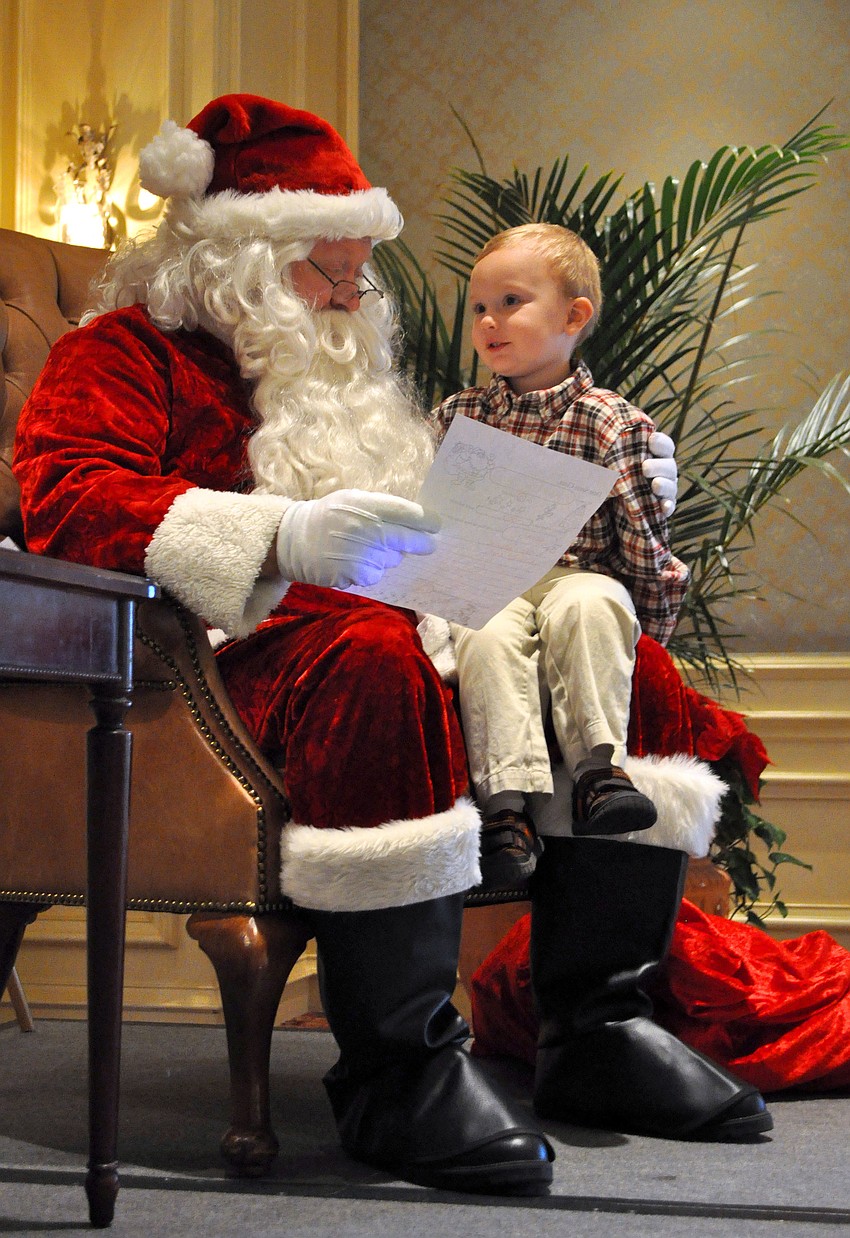 Santa and Charlie Meyer, 2, go over the things Charlie wants for Christmas.