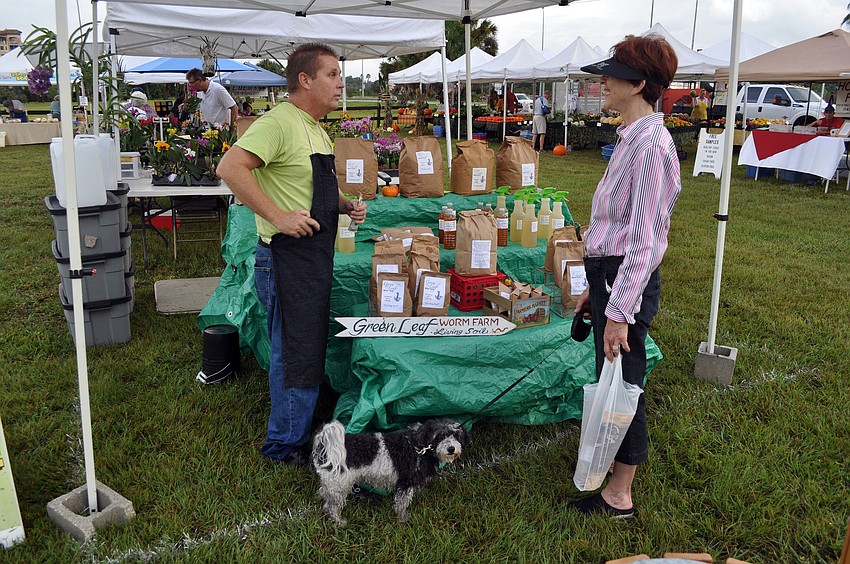 Sean Moore of Green Leaf Worm Farm sells some orchid spray to Melody Oxarat Wednesday, Oct. 3.