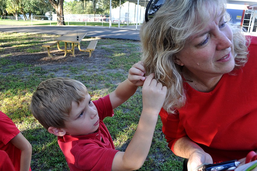 Nathan Shulman, 5, helps his teacher, Debbie Lacy, get a ladybug out of her hair.