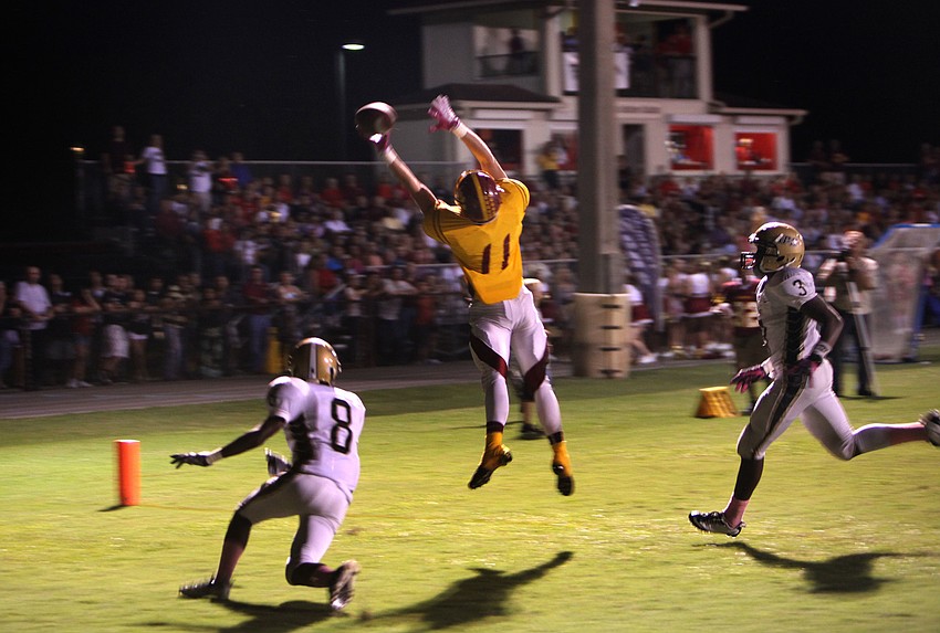 Casey Gunderson, No. 11, jumps up to try and catch a pass from his teammate while St. Petersburg Catholic players, Adrian Snead, No. 8, and Tony Jones, No. 3, stay close.