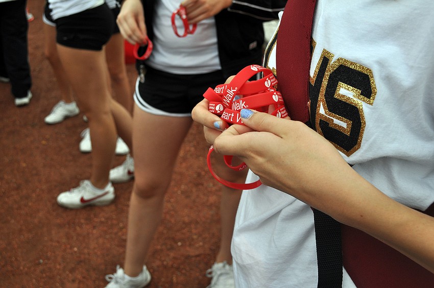 The Cardinal Mooney JV cheerleaders handed out Heart Walk bracelets as people completed their first lap of the walk.
