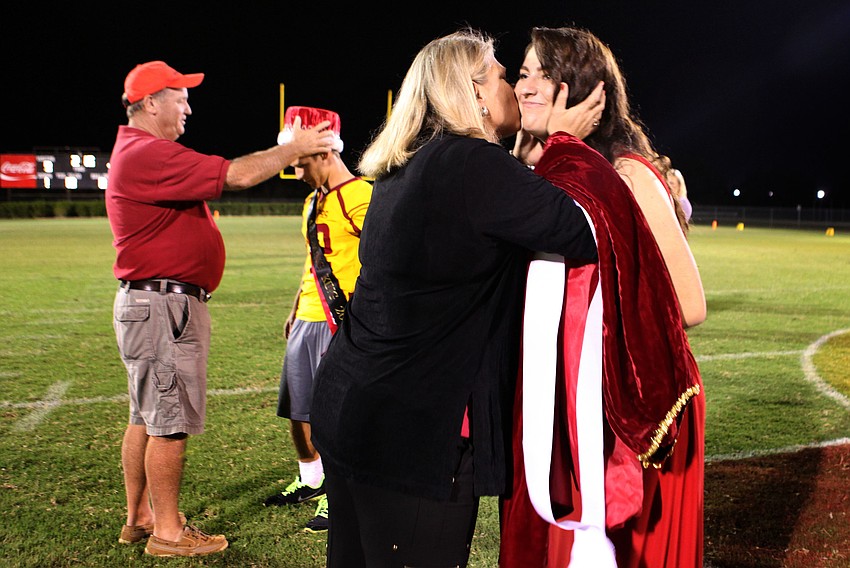 Principal Steve Christie crowns homecoming king Anthony Caiazzo while Kim Montgomery, mother of the 2011 homecoming queen, Annie Montgomery, crowns Sarah Soscia Friday, Oct. 12, during Cardinal Mooneyâ€™s homecoming game.